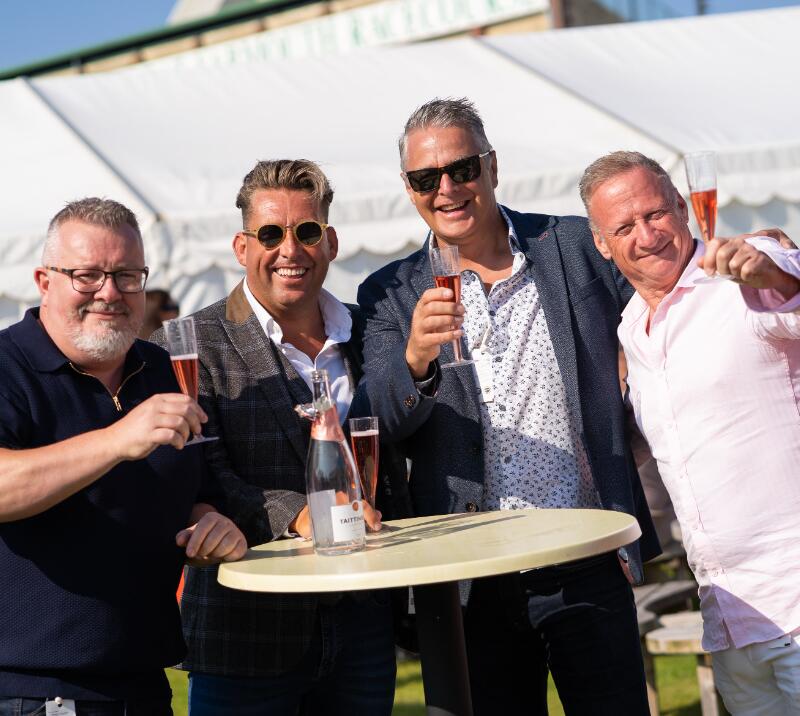 A group of racegoers enjoying a glass of prosecco