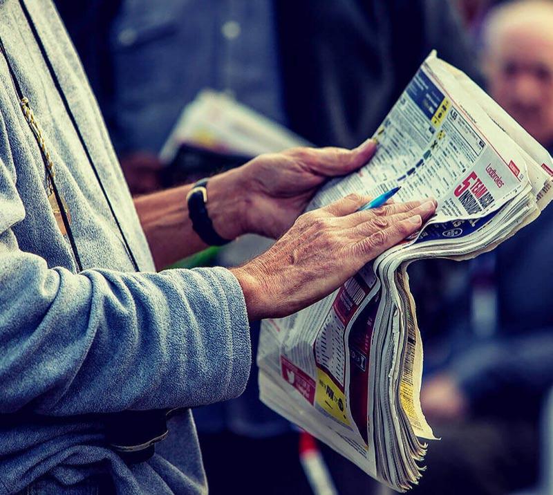 Racegoer reading through a newspaper.