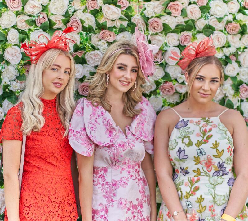 Three young women pose in front of the flower wall at Great Yarmouth
